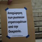 a couple of people standing next to each other holding signs